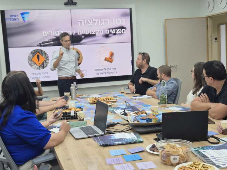 Guy Mor delivering a presentation on the 'Neto Regulation' initiative during a professional workshop.