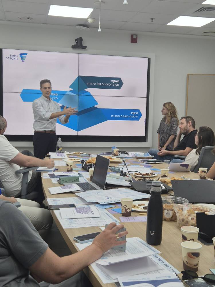 Guy Mor, a public policy expert, explains regulatory frameworks during a professional seminar.