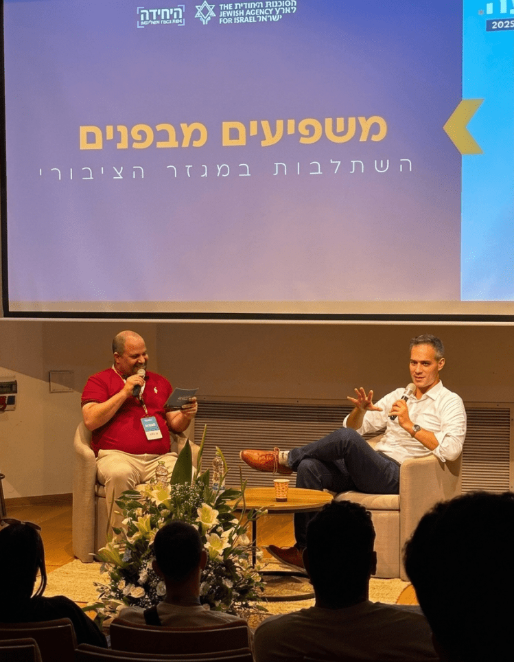 Guy Mor speaking in a live interview about public policy and entering the public sector at a professional event
